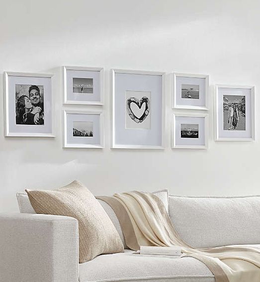 Wall with black and white images framed in white frames